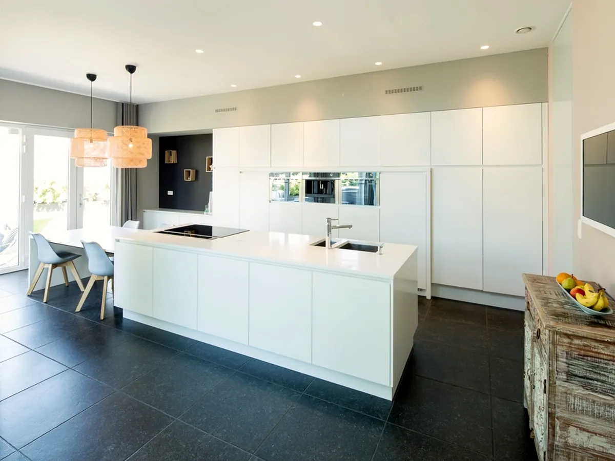 A white kitchen with an island in a newly built apartment; list the kitchen appliances in the contract